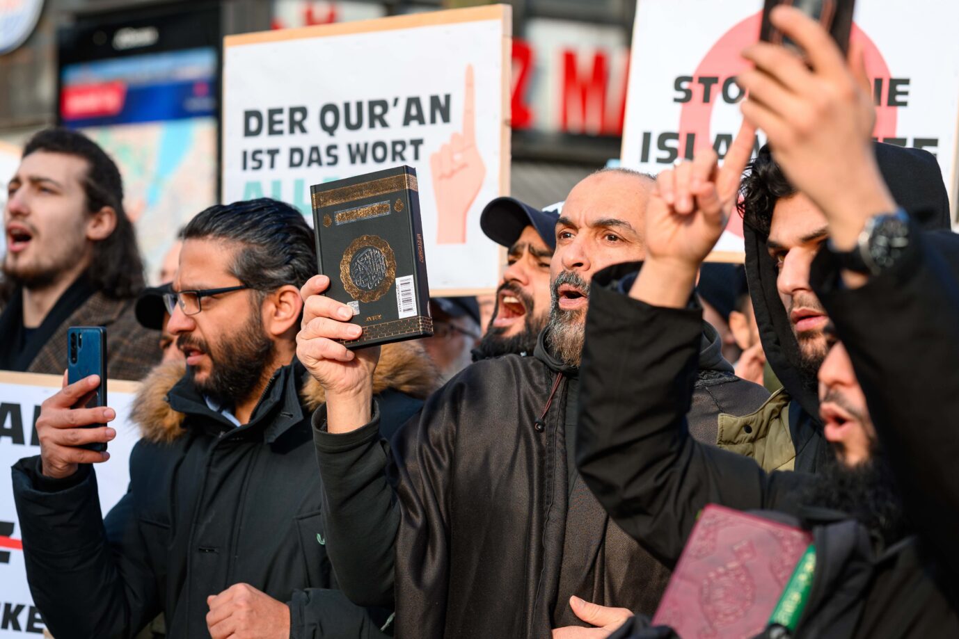 Teilnehmer einer islamistischen Demonstration in Hamburg halten eine Ausgabe des Koran in die Höhe. Laut dem BKA snd 83 Prozent aller Gefährder in Deutschland der islamistischen Szene zuzuordnen