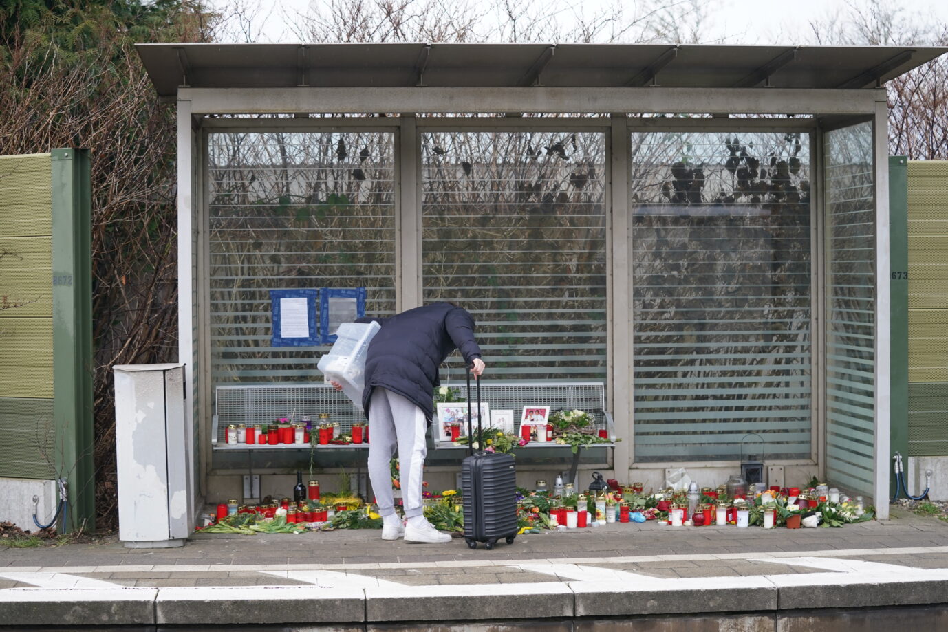 Eine Reisende steht vor den Blumen, die an die Opfer des Brokstedter Messerangriffs erinnern. Tatverdächtig ist der Palästinenser Ibrahim A.