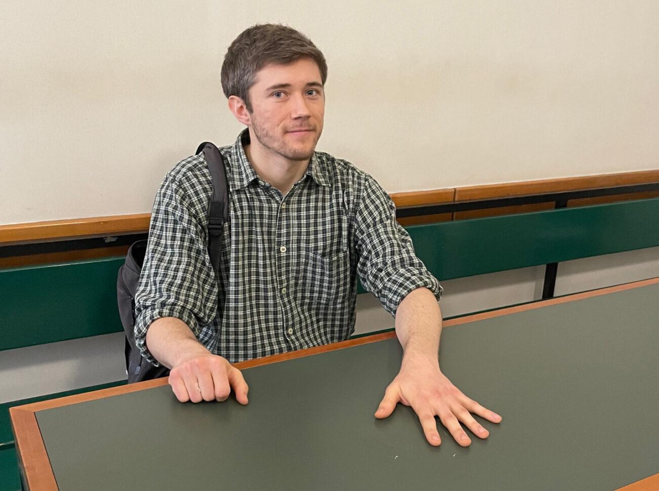 Der radikale Klimaschützer Henning Jeschke sitzt festgeklebt an einem Tisch in einem Raum des Amtsgericht Tiergarten
