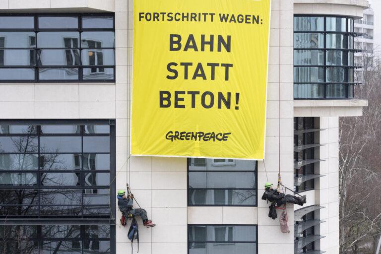 Greenpeace-Anhänger seilen sich vom Dach des Willy-Brandt-Hauses ab und zeigen ein Banner