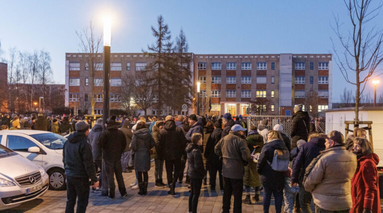Bürger versammeln sich zum Protest gegen die neue Asylunterkunft in Greifswald vor der Schule, wo die Ortsteilvertretung tagt.