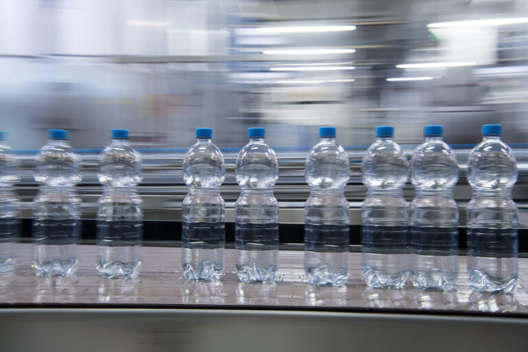 Wasserflaschen eines Getränkeherstellers auf dem Fließband: Noch heute gibt es Firmenpleiten als Folge der Lockdowns.