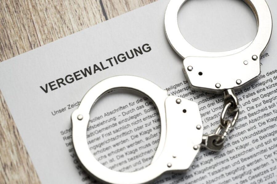 Brief mit Anklage: Vergewaltigung. Handschellen. Symbolbild