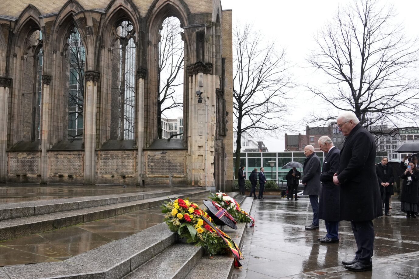 Britain's King Charles III, center, and German President Frank-Walter Steinmeier, right, lay a wreath of flowers at St. Nikolai Memorial in Hamburg, Germany, Friday, March 31, 2023. King Charles III arrived Wednesday for a three-day official visit to Germany. (AP Photo/Matthias Schrader)