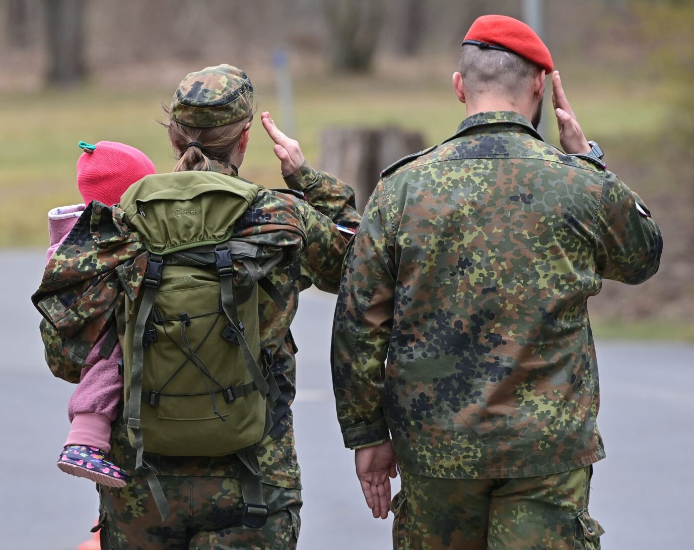 Eine Soldatin der Bundeswehr trägt ihr kleines Kind auf dem Arm am Rande eines feierlichen Appells zur Indienststellung des ABC-Abwehrregiments 1 in der Barnim-Kaserne. Gleichstellungsbeauftragte sollen den Frauenanteil steigern.