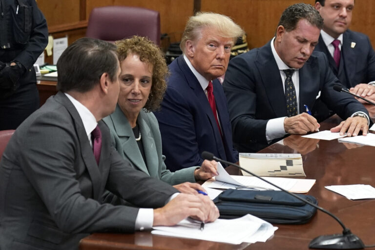 Ex-US-Präsident Donald Trump (m.) sitzt zwischen seinen Anwälten vor Gericht.