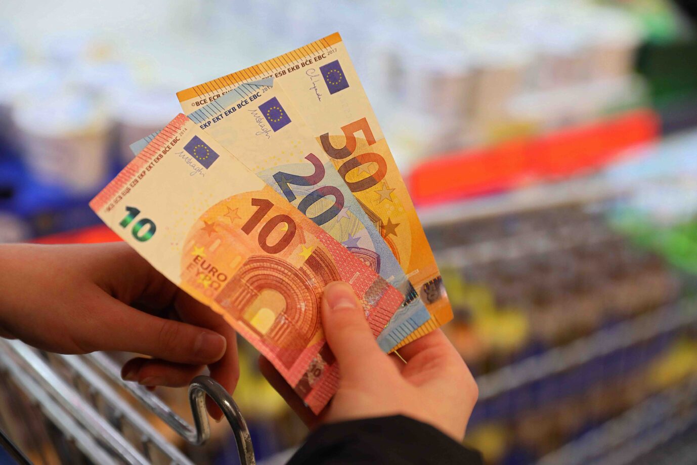 Eine Person hält beim Einkaufen vor seinem Einkaufswagen Euroscheine in der Hand. Der Reichtum der Deutschen ist laut der Bundesbank auch 2021 weiter gestiegen.