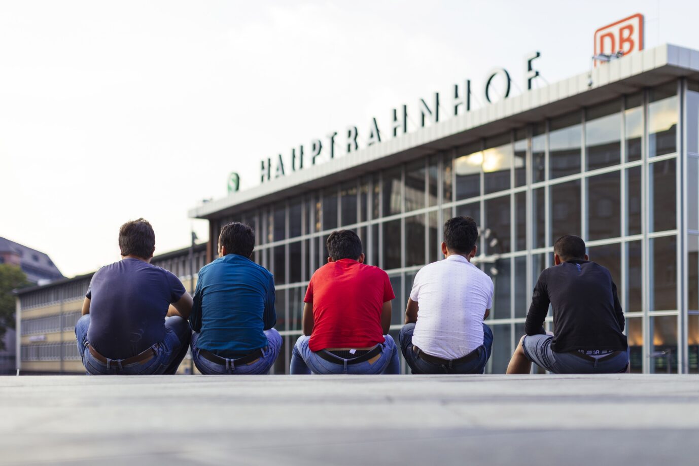 Migranten sitzen auf der Bahnhofstreppe am Kölner Hauptbahnhof. Köln, 24.07.2018. Kamen sie als Asylbewerber?