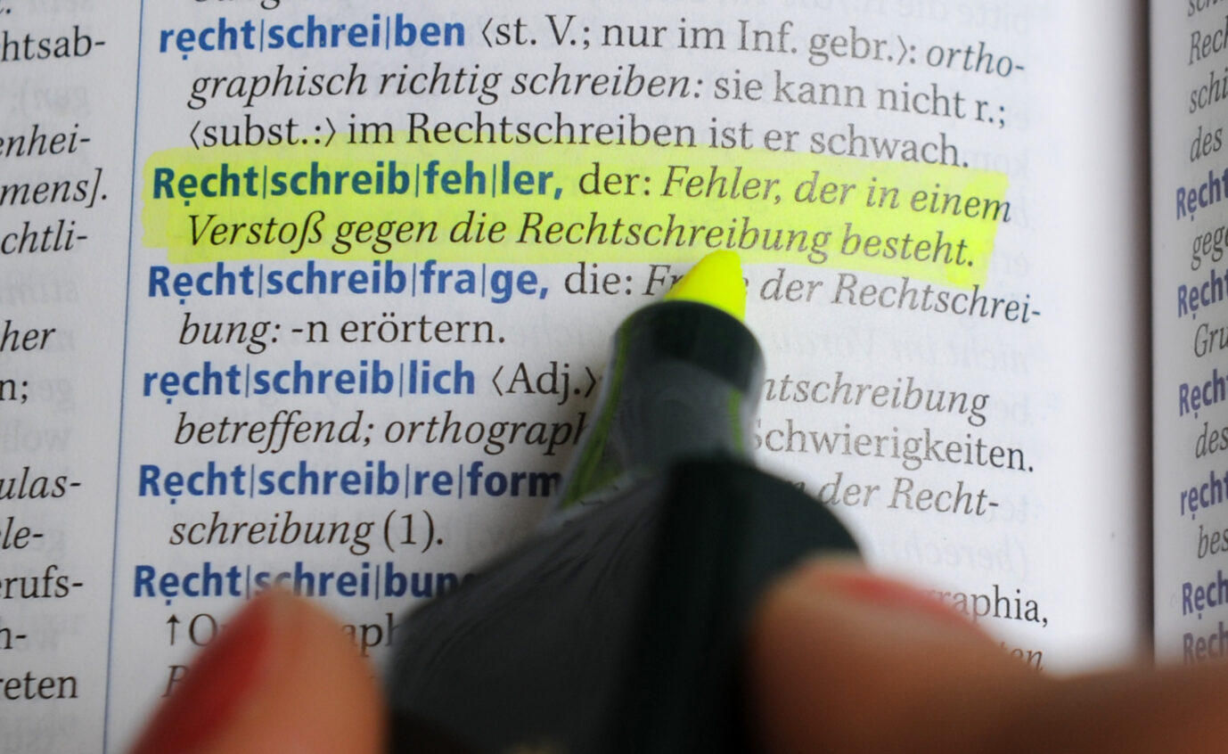 Eine Frau markiert mit einem Textmarker den Eintrag zum Wort "Rechtschreibfehler" in einem Deutschen Universalwörterbuch (Duden). Gendern führt zu vielen Sprachfehlern.