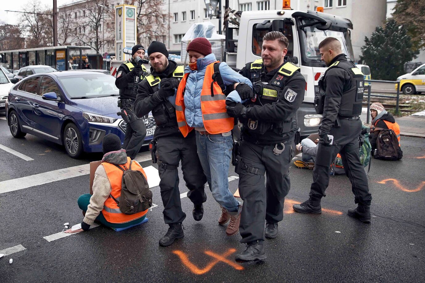 Die Polizei trägt in Berlin einen Klimakleber weg. Die Gebühren für die Einsätze übernimmt die Ökoworld AG.
