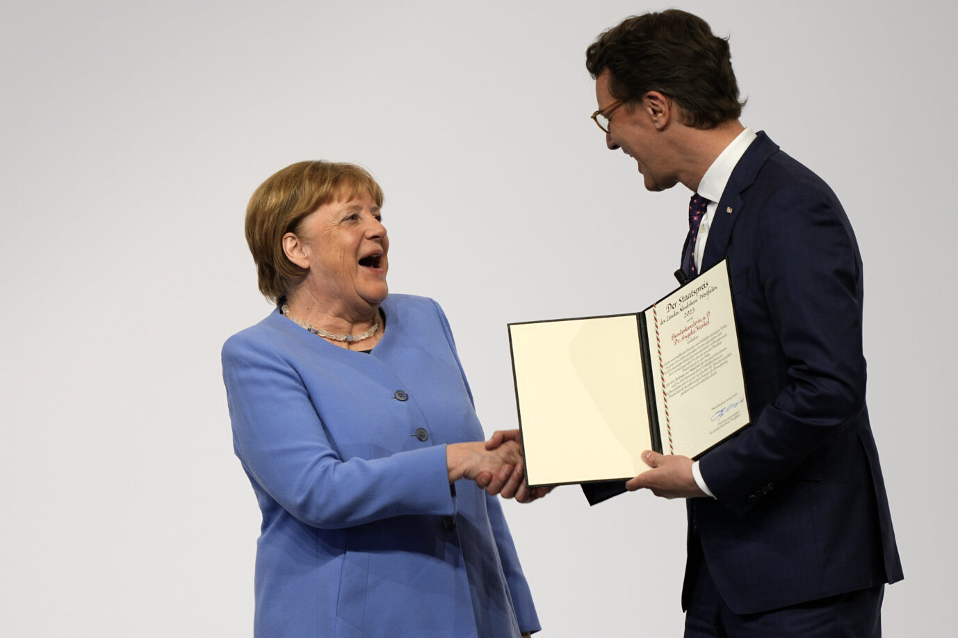Altkanzlerin Angela Merkels und Nordrhein-Westfalens Ministerpräsident Hendrik Wüst (CDU): Der Landeschef findet die Ehrung gerechtfertigt