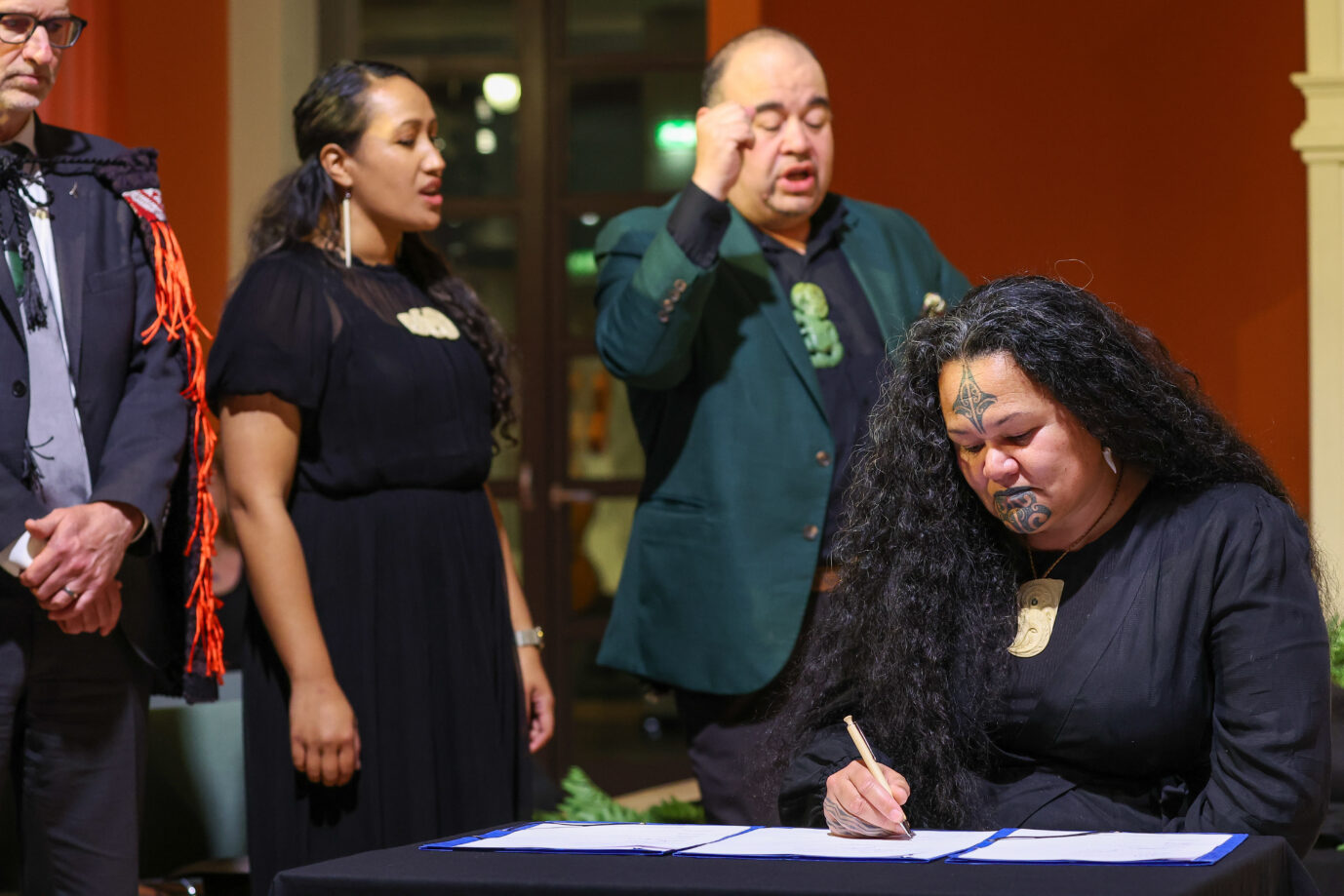 Eine Indigene aus Neuseeland unterzeichnet die Rückgabeerklärung von Exponaten in Leipzig