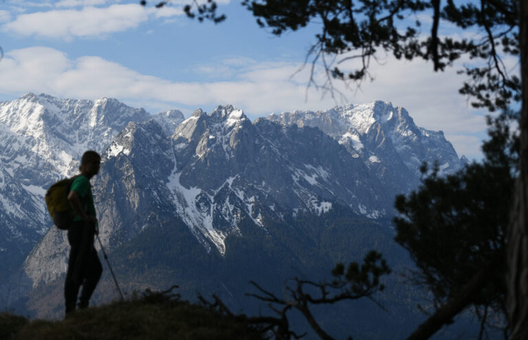 Ein Wanderer blickt auf den schneebedeckten Gipfel der Zugspitze, Bergwandern begeistert.