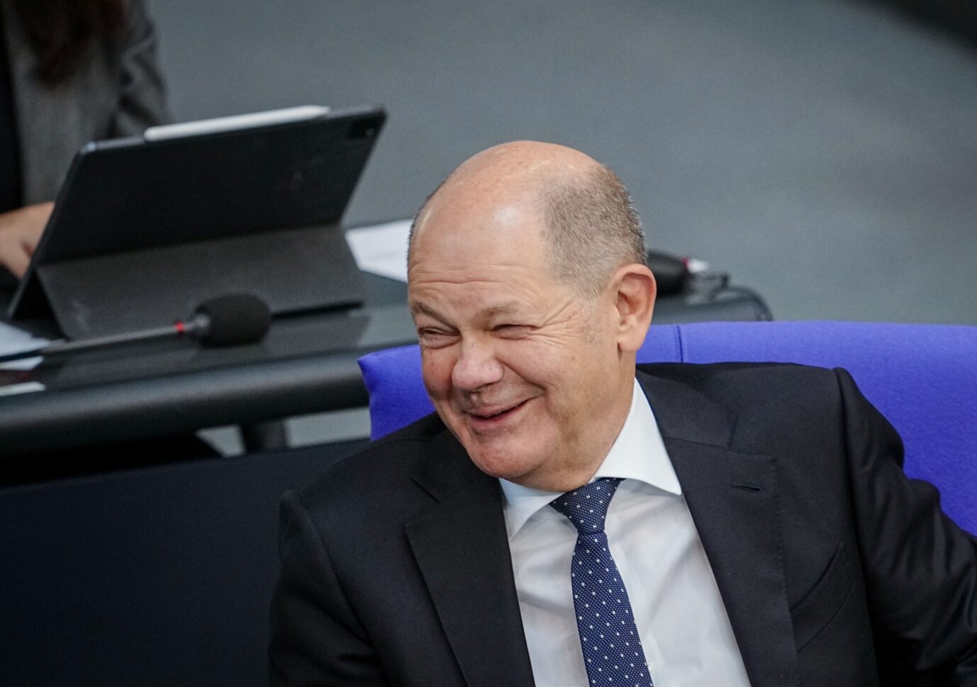 Bundeskanzler Olaf Scholz (SPD) amüsiert sich im Bundestag. Über seinen Witz zur Migration konnten nur wenige Linke lachen.