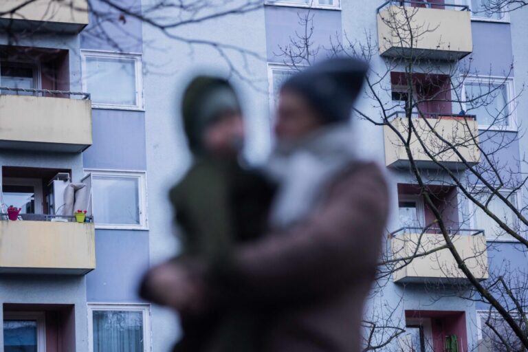 Familie - Eine Mutter trägt ihr Kind durch ein Berliner Wohnviertel