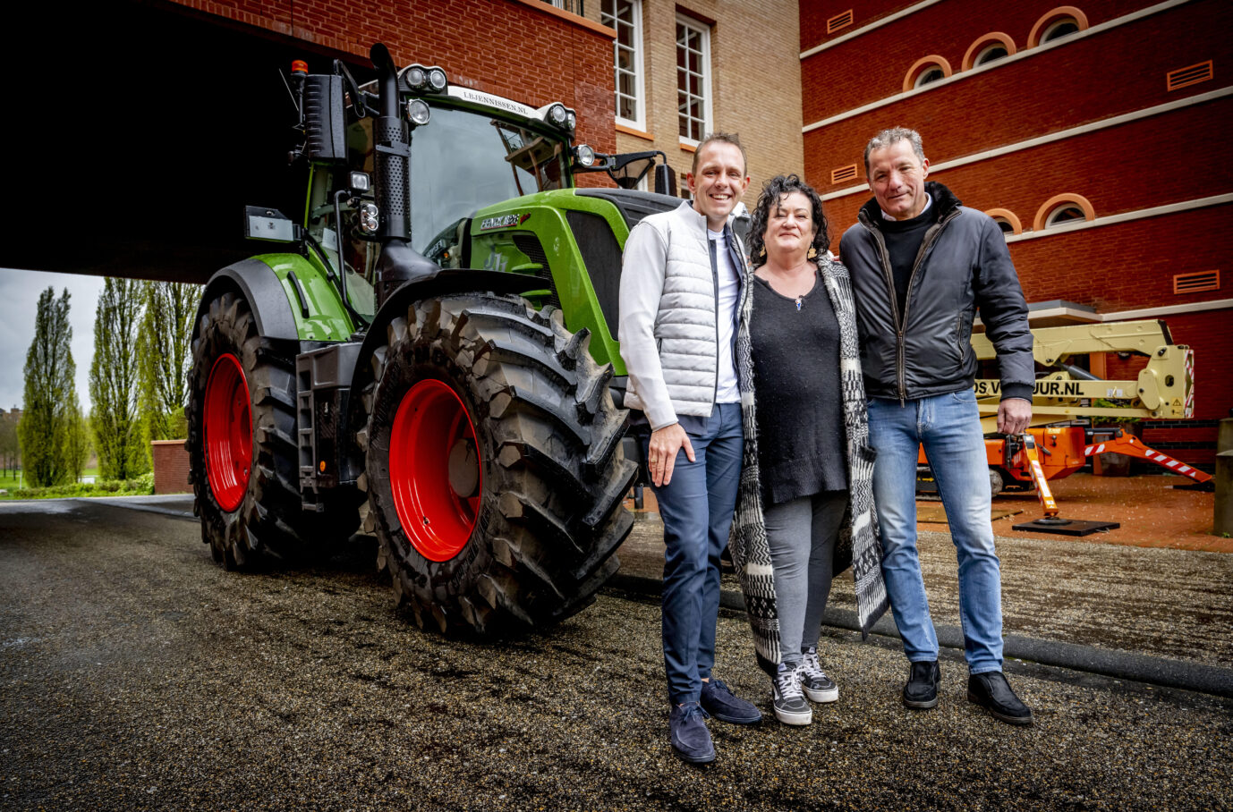 Das Foto zeigt die Vorsitzende der Bauernbürgerbewegung, Caroline van der Plas vor einem Traktor mit zwei Bekannten.