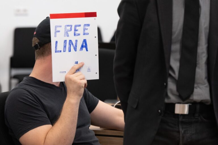 Linksextremismus: Ein Mitangeklagter hält im Gerichtssaal die in der linksradikalen Szene verbreitete Forderung nach Freilassung Lina E.s hoch.
