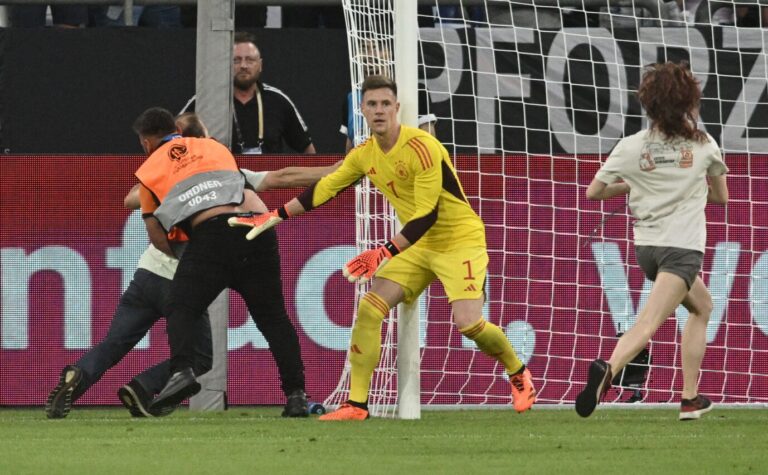 Nachdem ein Linksradikaler abgewehrt ist, hält Nationaltorwart Marc-André Ter Stegen auch die Frau ab, die sich ans Tor ketten will. Foto: picture alliance/dpa | Bernd Thissen