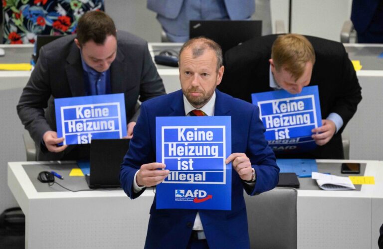 Stefan Marzischewski-Drewes (AfD) und weitere Fraktionsmitglieder der Alternative für Deutschland halten im niedersächsischen Landtag während der Debatte über Klimawandel Schilder mit Aufschrift „Keine Heizung ist illegal“.