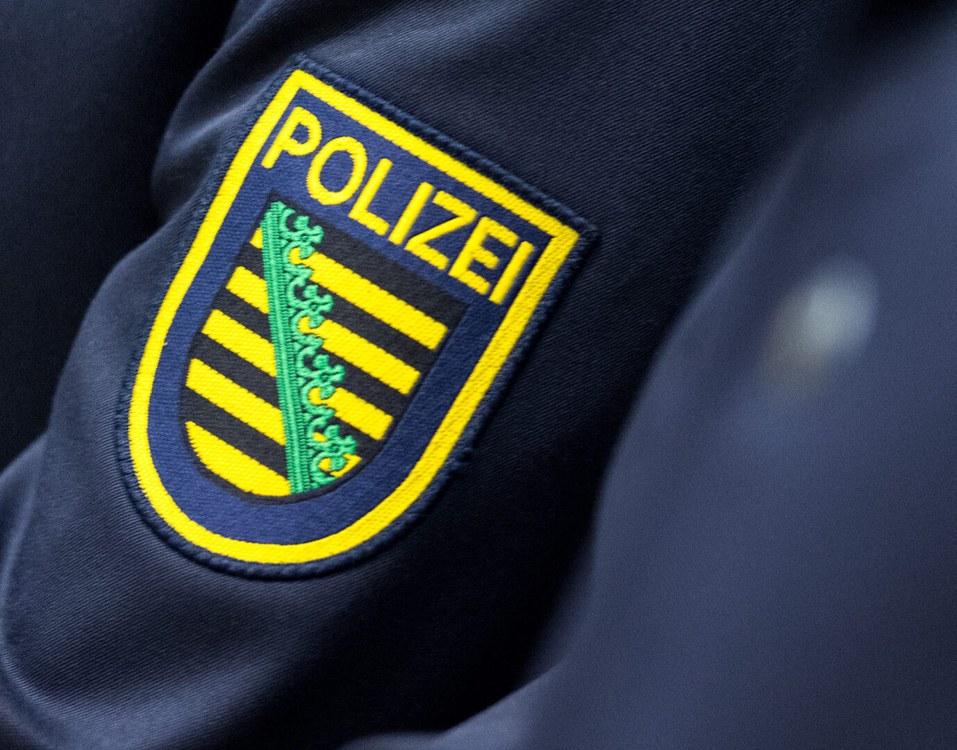 Das Wappen von Sachsen ist auf einer Polizeiuniform angebracht. Nunbgab es einen Angriff auf einen rechtsextremen.