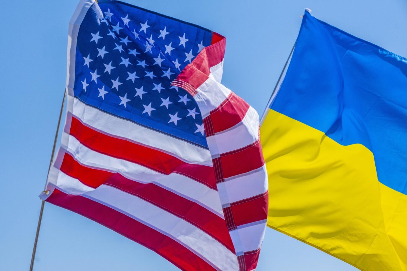 Das Bild zeigt die wehenden Flaggen der USA und der Ukraine.