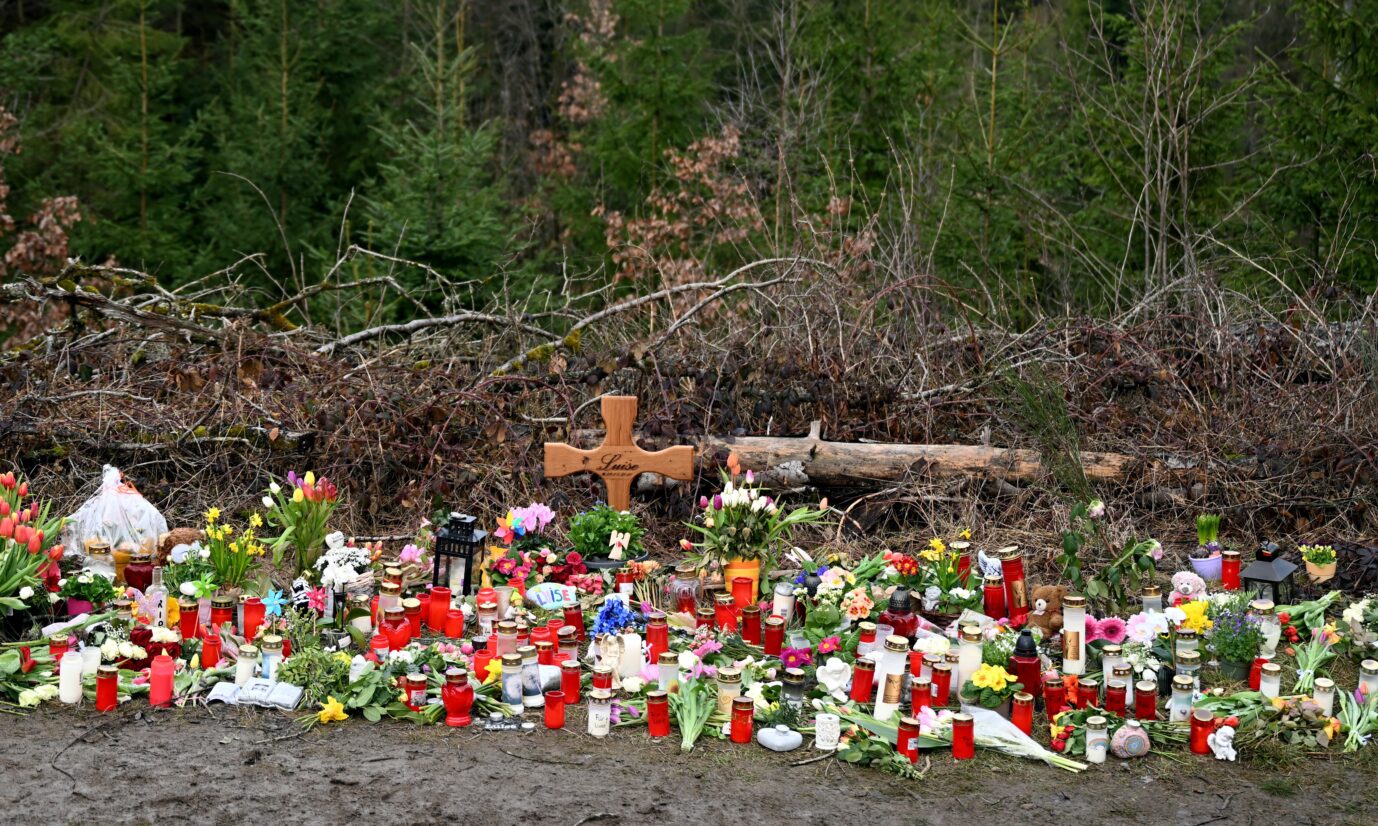 Am Rande des Waldes, in dem die Mädchen Luise ermordeten, haben Anwohner Blumen und Kerzen abgelegt sowie ein Holzkreuz errichtet.