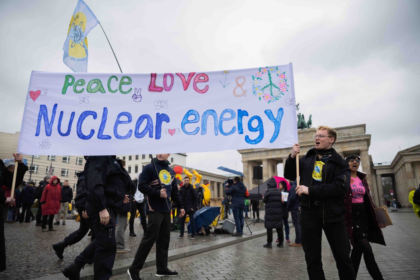 Teilnehmer eines Protests gegen die Abschaltung der letzten drei deutschen Kernkraftwerke des Vereins Nuklearia stehen am 15. April 2023 mit einem Banner vor dem Brandenburger Tor Foto: picture alliance/dpa | Christoph Soeder