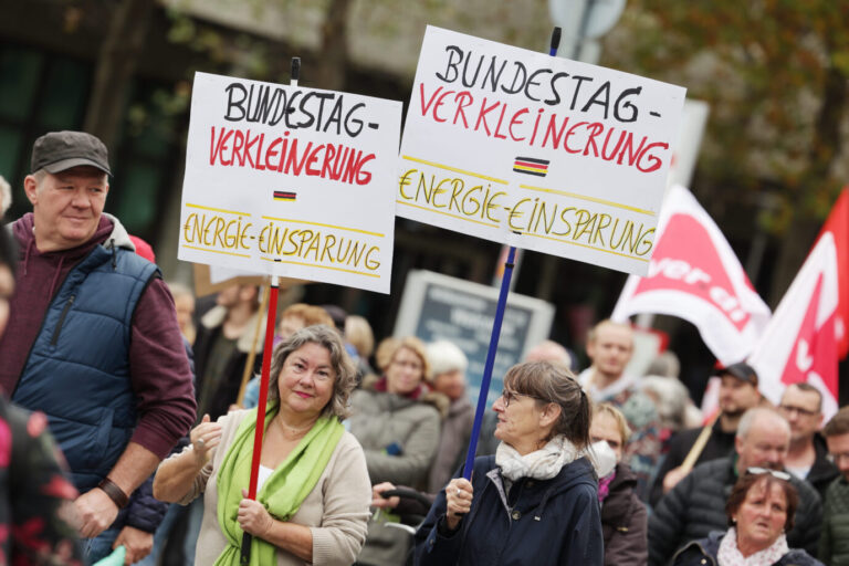 Zwei Teilnehmerinnen tragen Plakate mit dem Aufschrift 'Bundestag Verkleinern- Einergi€ €insparung'. Ein Sozialbündnis hat zu bundesweiten Demonstrationen aufgerufen, gefordert werden weitere kurzfristig wirksame Entlastungsmaßnahmen, ein Strompreis- und Gaspreisdeckel, weitere Energiegeldzuschüsse sowie die Beendigung der Abhängigkeit von fossilen Energien. Vertrauen in Demokratie sinkt.