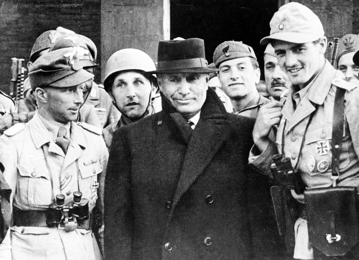 Italiens Diktator Benito Mussolini (m.) ist nach der Befreiung umringt von deutschen Fallschirmjägern.