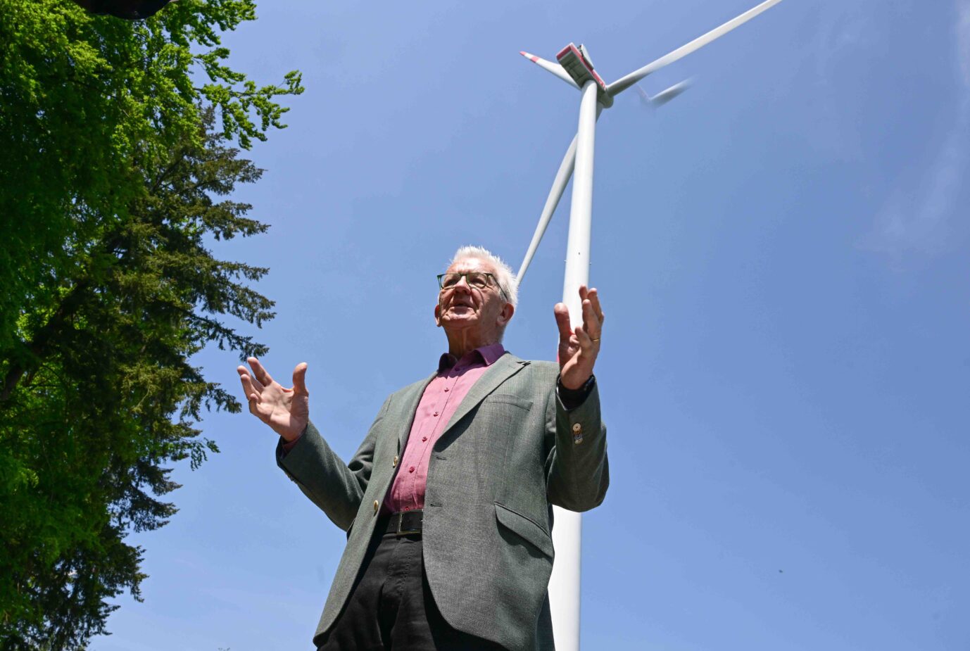 Baden-Württembergs Ministerpräsident Winfried Kretschmann unter einem Windrad: Subventionen statt Atomenergie Foto: picture alliance/dpa | Bernd Weißbrod