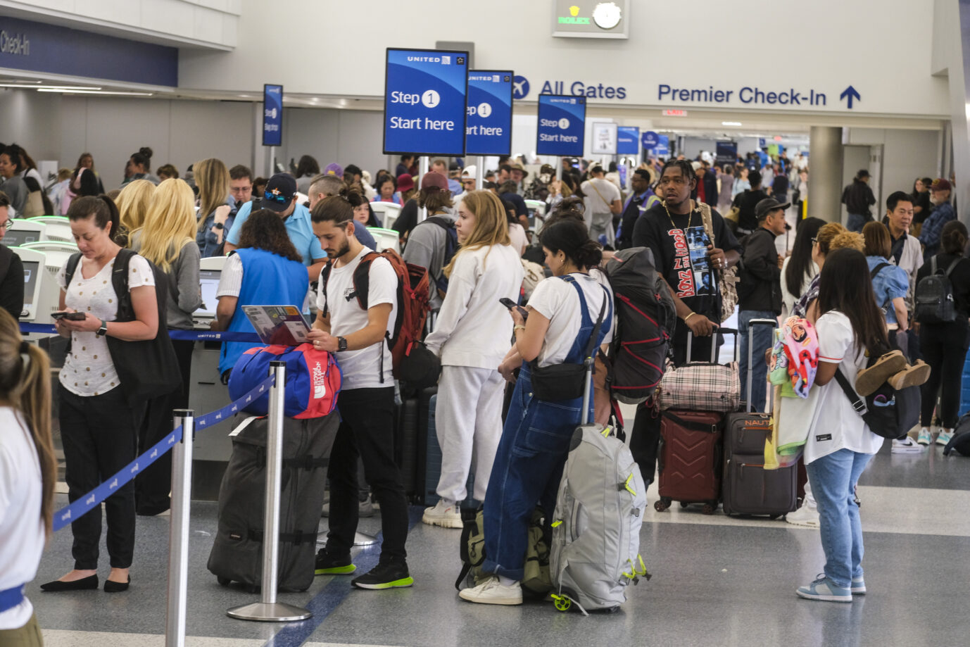 Flugpassagiere stehen Schlange: Völkerverständigung profitiert vom Reisen.