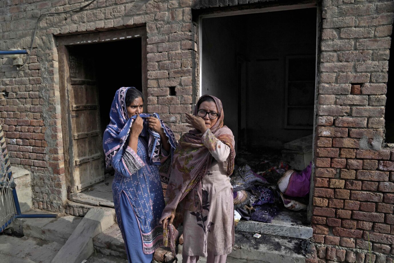 Zwei Christen stehen weinend vor den Überresten ihrer Wohnung im pakistanischen Jaranwala Foto: picture alliance / ASSOCIATED PRESS | K.M. Chaudary