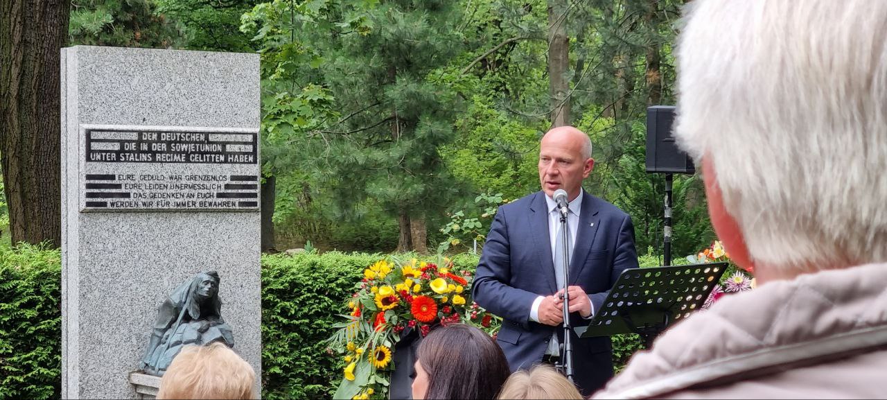 Das Bild zeigt Berlins Bürgermeister Kai Wegner (CDU) vor einem Gedenkstein für vertriebene Deutsche aus den Sowjetgebieten.