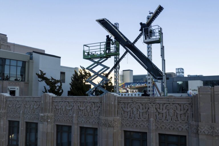 Arbeiter installieren das neue Firmenlogo auf der X-Zentrale von Elon Musk in San Francisco Foto: picture alliance / ASSOCIATED PRESS | Noah Berger