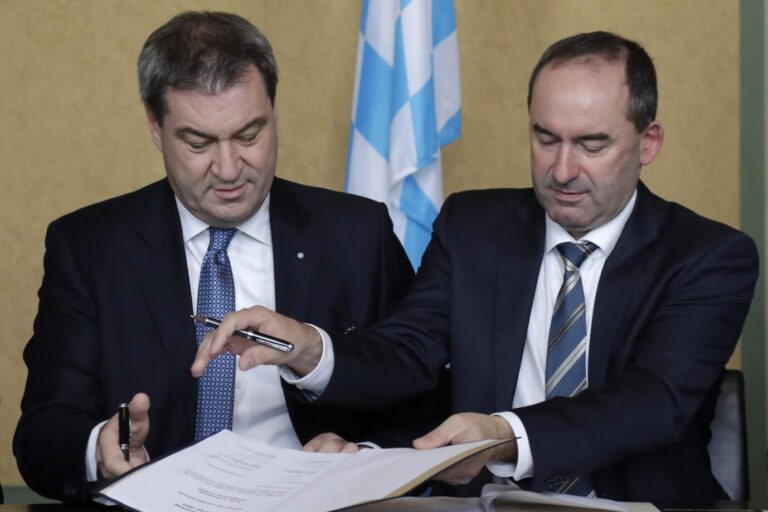 Bavarian State Governor Markus Soeder of the German Christian Social Union party CSU, left, and Hubert Aiwanger, chairman of the Free Voters in Bavaria, sign the coalition contract in Munich, Germany, Monday, Nov. 5, 2018. (AP Photo/Matthias Schrader)