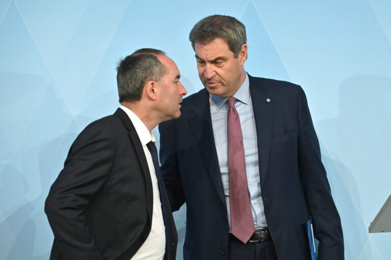 Ministerpräsident Markus Söder (CSU) legt die Hand auf den Arm von Wirtschaftsminister Hubert Aiwanger (Freie Wähler)