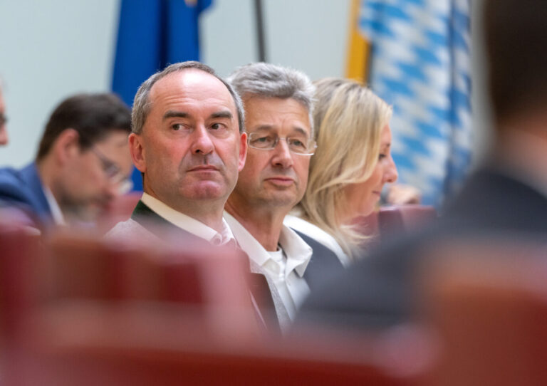 Hubert Aiwanger, (Freie Wähler) Stellvertretender Ministerpräsident und bayerischer Staatsminister für Wirtschaft, Landentwicklung und Energie, sitzt im Plenarsaal des bayerischen Landtag, vor seiner Regierungserklärung, auf seinem Platz. Hinter Aiwanger sitzt Michael Piazolo, (Freie Wähler) Staatsminister für Unterricht und Kultus. Thema sind unter anderem „Wohlstand sichern durch eine starke Wirtschaft“.