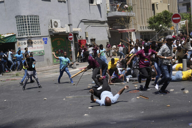 Anti-Eritrean government activists, left, clash with supporters of the Eritrean government, in Tel Aviv, Israel, Saturday, Sept. 2, 2023. Hundreds of Eritrean asylum seekers smashed shop windows and police cars in Tel Aviv on Saturday and clashed with police during a protest against an event organized by the Eritrea Embassy. The Israeli police said 27 officers were injured in the clashes, and at least three protesters were shot when police opened fire with live rounds when they felt "real danger to their lives." (AP Photo/Ohad Zwigenberg)