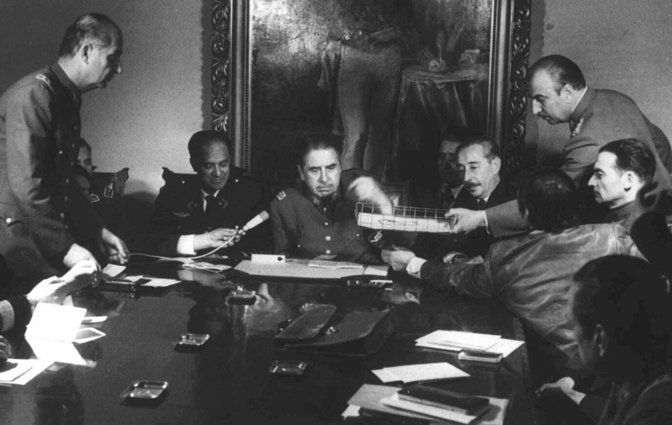 FILE - In this Sept. 20, 1973 file photo, Gen. Augusto Pinochet, center, presides over a meeting with his military staff in Santiago, Chile, days after seizing power from President Salvador Allende. As Chile marks the 40th anniversary of the military coup on Wednesday Sept. 11, 2013 that was led by Pinochet, Allende's legacy is thriving. A socialist is poised to reclaim the presidency and a new generation, born after the return to democracy in 1990 has taken to the streets in vast numbers to demand the sort of social goals Allende promoted. (AP Photo/File)