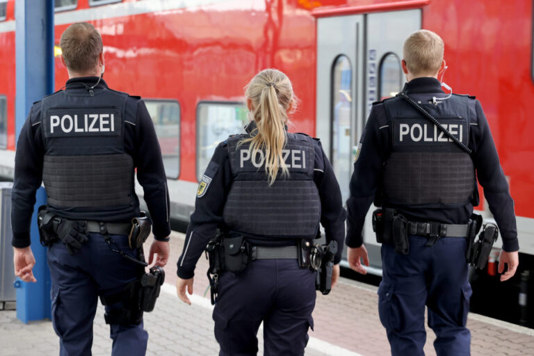 Auf dem Foto laufen drei Bundespolizisten. Vor ihnen steht ein Zug der Deutschen Bahn. (Symbolbild)
