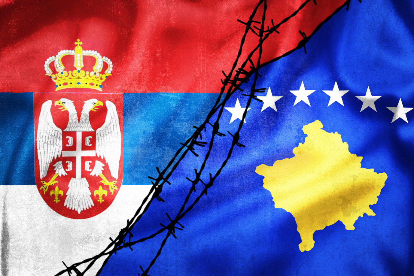 Grunge flags of Serbia and Kosovo divided by barb wire illustration, concept of tense relations between Serbia and Kosovo