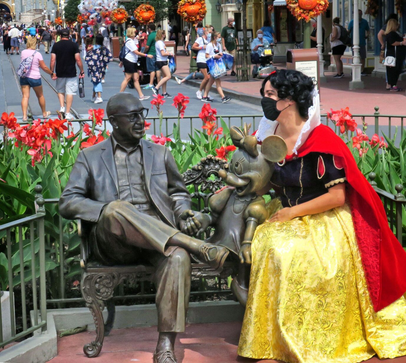 Auf dem Foto befindet sich eine maskierte Frau im Schneewittchen-Kostüm neben einem Denkmal von Roy E. Disney. (Themenbild)