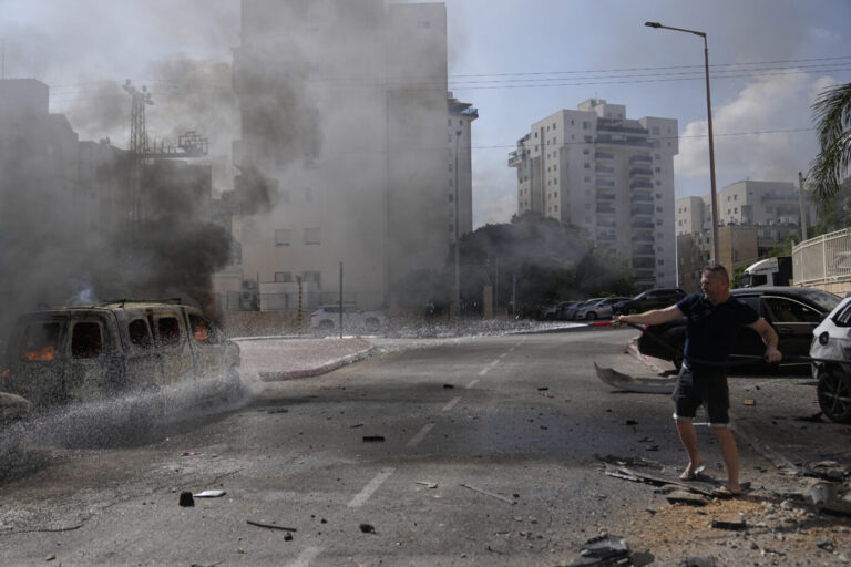 Cars are on fire after they were hit by rockets from the Gaza Strip in Ashkelon, Israel, on Saturday, Oct. 7, 2023. Palestinian militants in the Gaza Strip infiltrated Saturday into southern Israel and fired thousands of rockets into the country while Israel began striking targets in Gaza in response. (AP Photo/Ohad Zwigenberg)