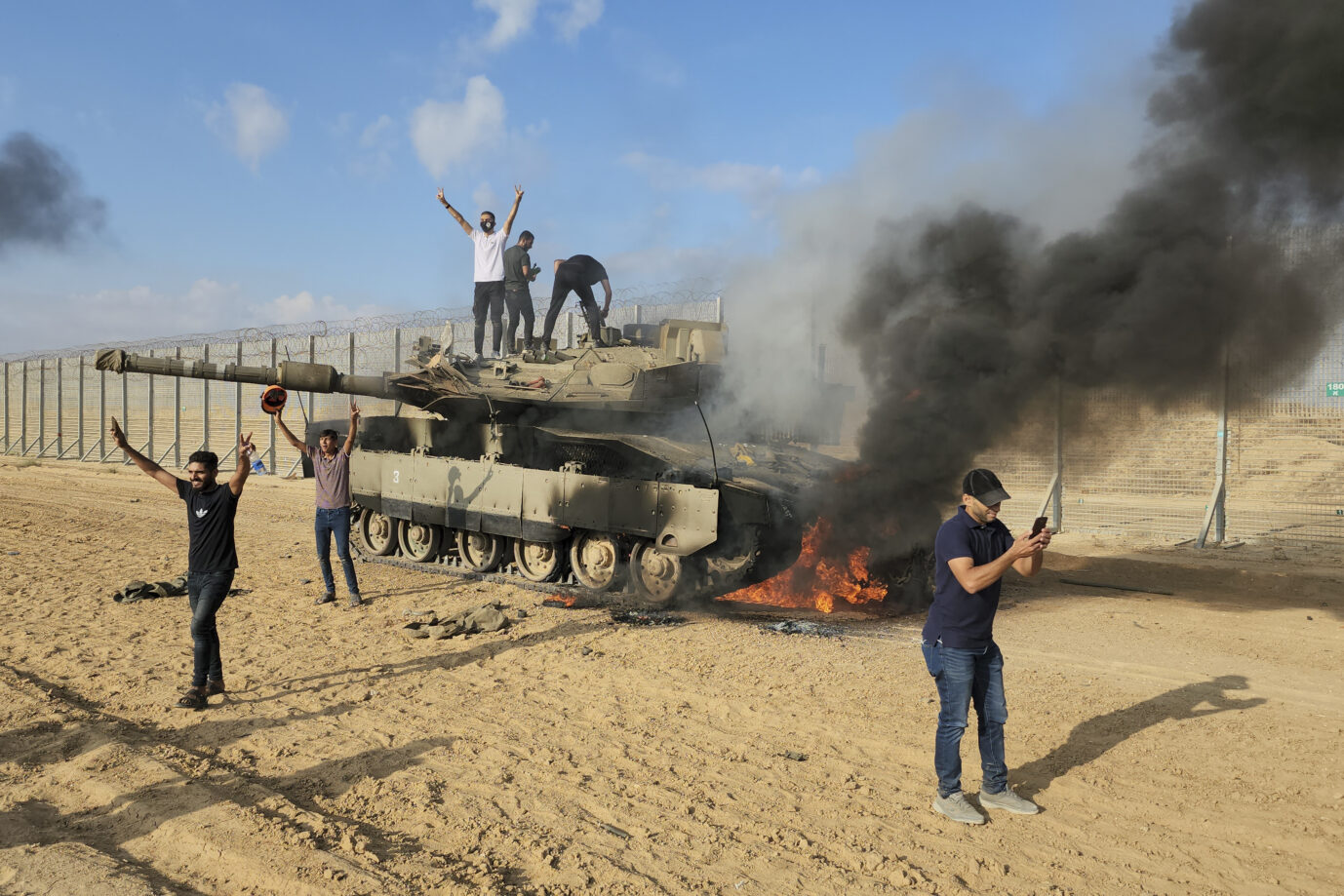 Auf dem Foto ist ein Bild aus Israel, auf dem sich Araber über einen brennenden Panzer freuen.