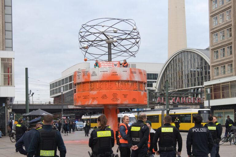 Die Klima-Ideologen der „Letzten Generation“ sitzen auf der Weltzeituhr nach ihrer Farbattacke, die Polizei schaute nur zu Foto: picture alliance/dpa | Paul Zinken