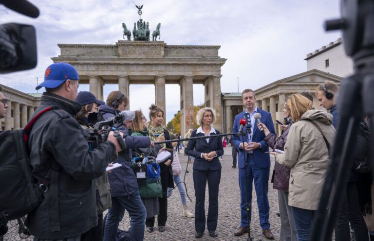 Stefan Evers (l, CDU) und Birgit Möhring (r) geben ein Pressestatement am Brandenburger Tor. Die Reinigung wird noch mehrere Wochen dauern. Die Letzte Generation will es erneut besprühen.