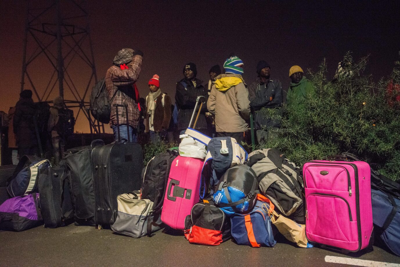 Migranten sind mit Koffern unterwegs.