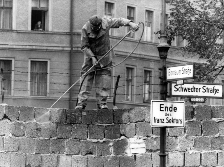 Ein ostberliner Arbeiter spritzt Farbe auf die Berliner Mauer: Die deutsche Teilung hat Künstler auf beiden Seiten des Eisernen Vorhangs entscheidend geprägt.
