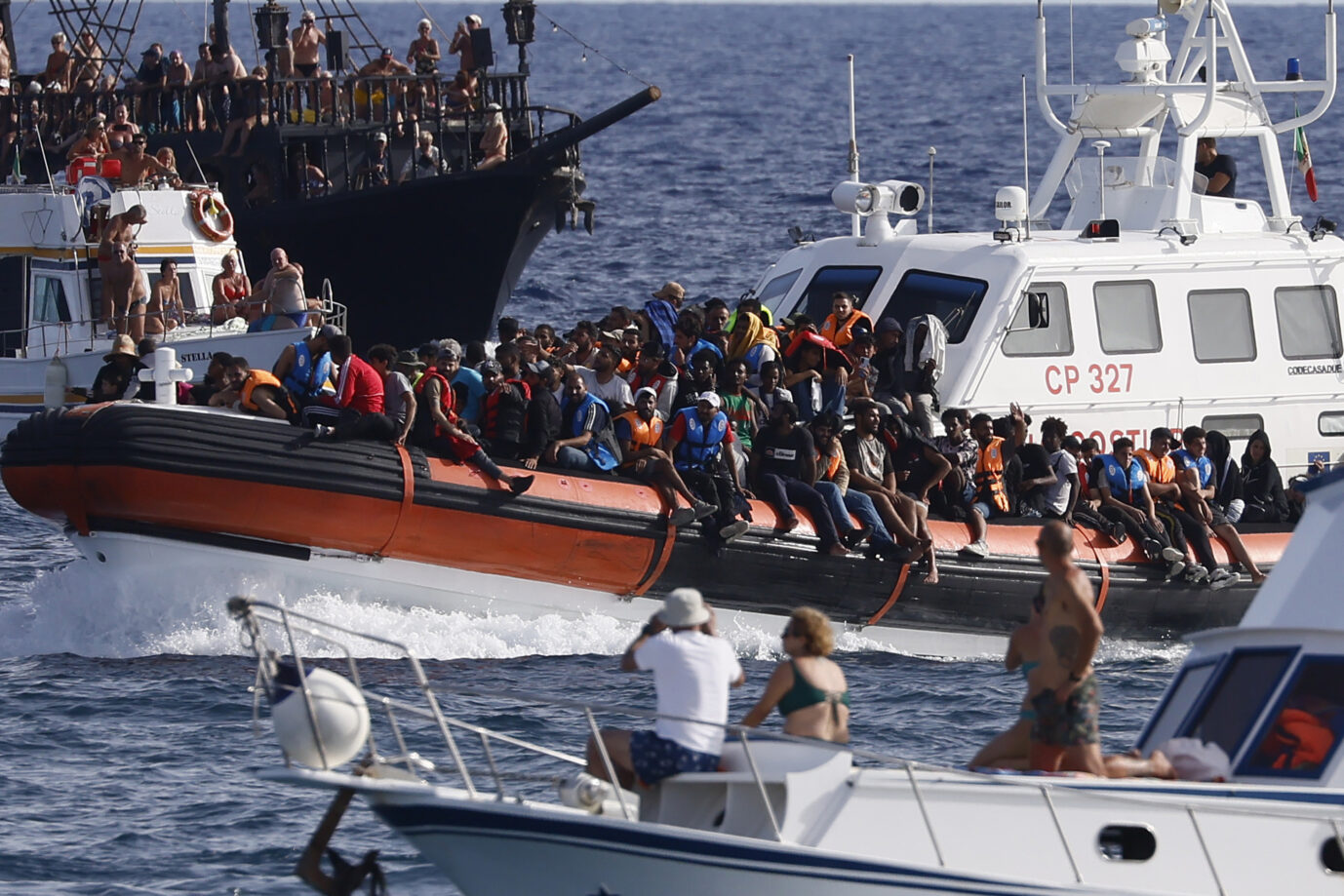 Ein Boot mit Afrikanern und Arabern erreicht die Küste Italiens: Hinter der Migration steht ein finanzstarkes Netzwerk.