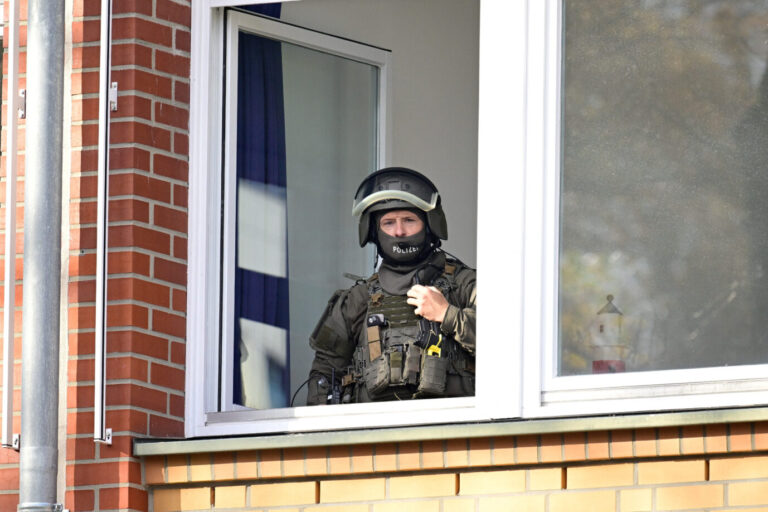 A police officer looks on from a window as police check reports of a threat situation at a school in the Blankenese district after local media said that two armed people had barricaded themselves in a classroom in Hamburg, Germany, November 8, 2023. REUTERS/Fabian Bimmer